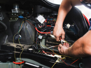 Auto technician working on a car's electrical system.