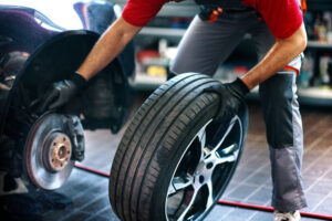 Auto technician removing the tire on a car.