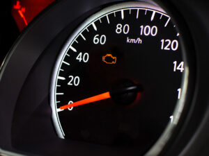 Car dashboard with check engine light illuminated.