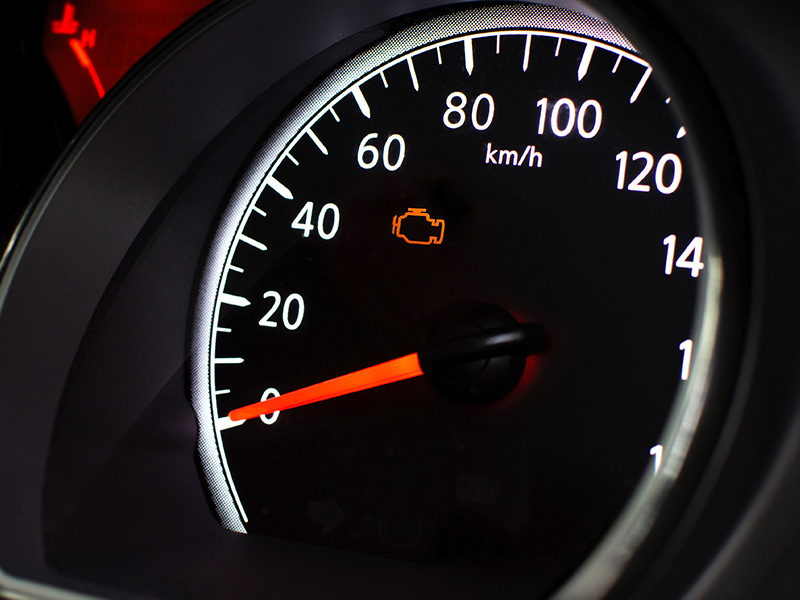 Car dashboard with check engine light illuminated.