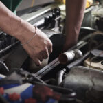 Auto mechanic working on the radiator of a car.